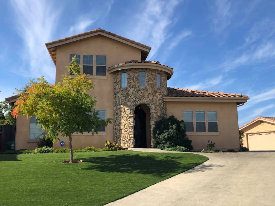 A large house with a big driveway and lots of grass.